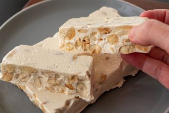 طرز تهیه نوقای ترد و کش دار خانگی با سفیده تخم مرغ، عسل و بادام
